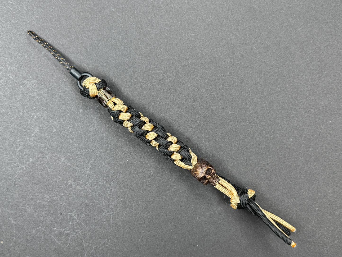 Custom Knife Lanyard โ Black & Gold Paracord with Handmade Skull Bead